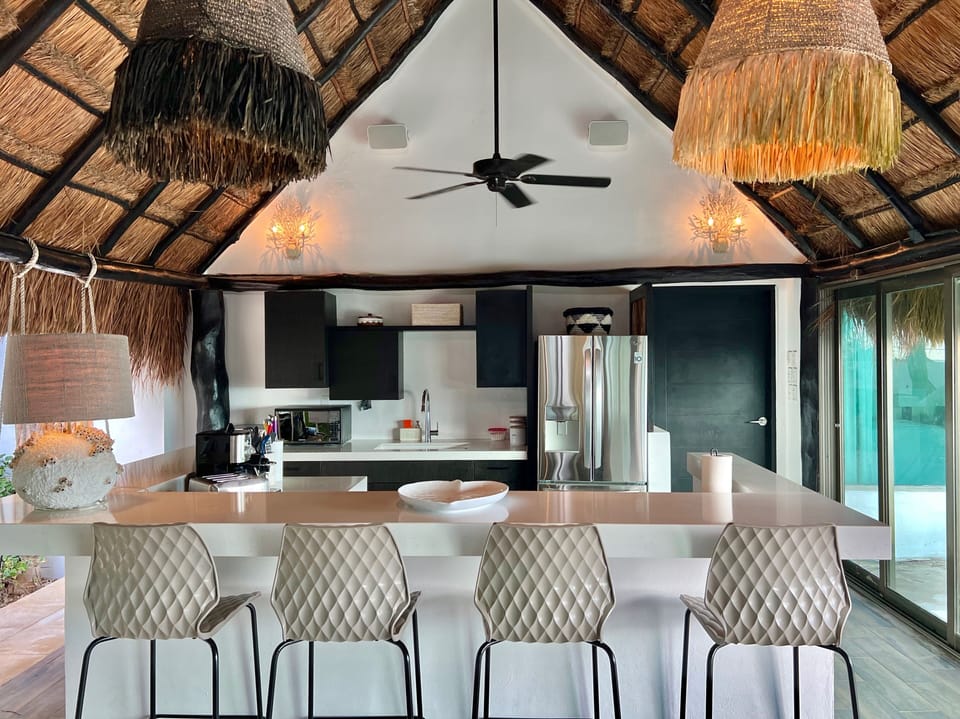 The kitchen counter doubles as a bar complete with 2 swing chairs.