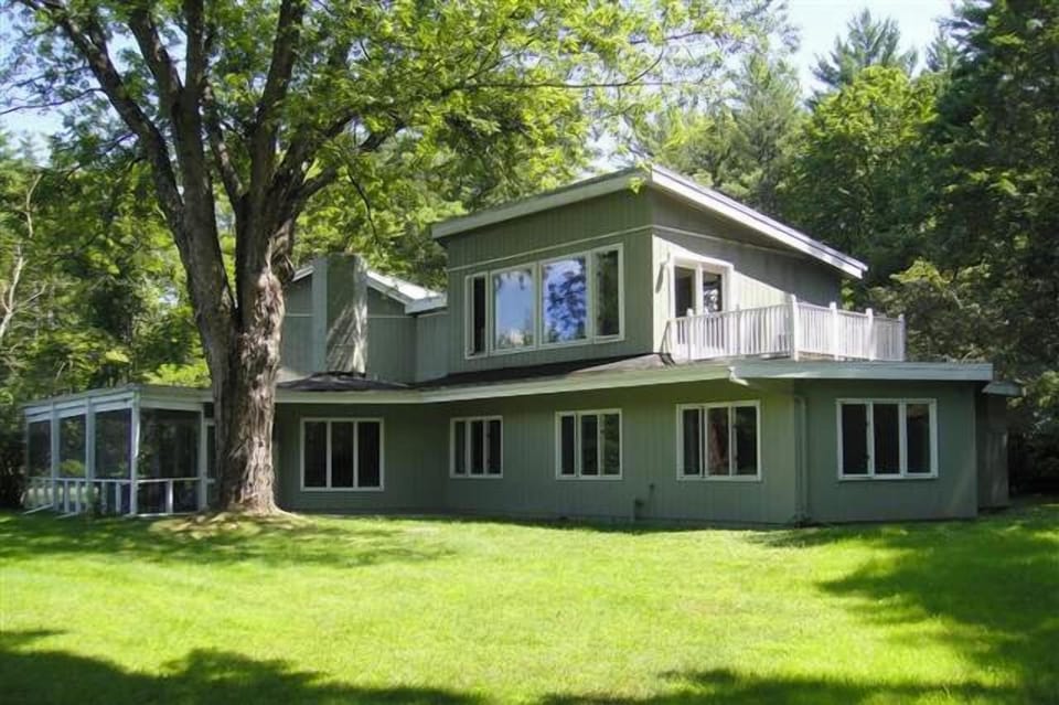 back of house with windows onto mountain view