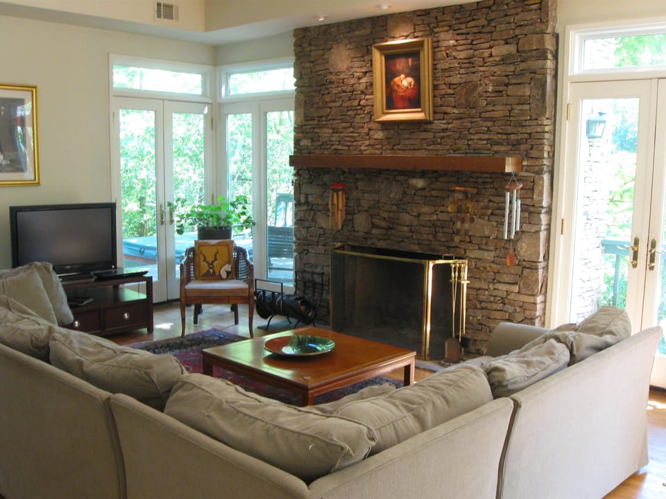 Cozy conversational area, classic stone fireplace, hot tub on deck, huge porch