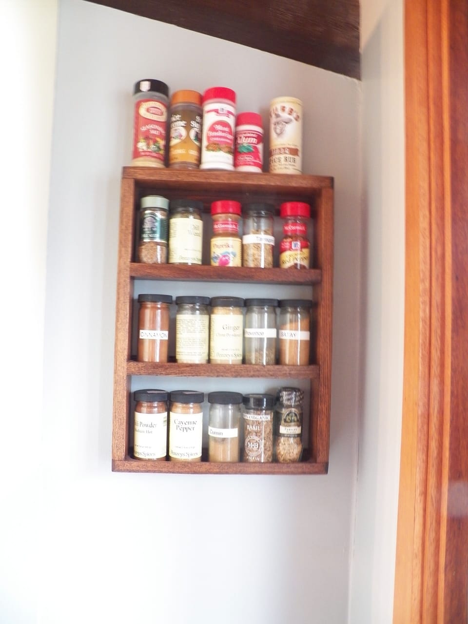 Plenty of spices on the kitchen spice rack.