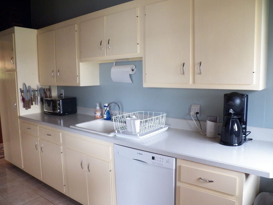 Kitchen has a drip coffee maker, coffee grinder, toaster oven and pop-up toaster