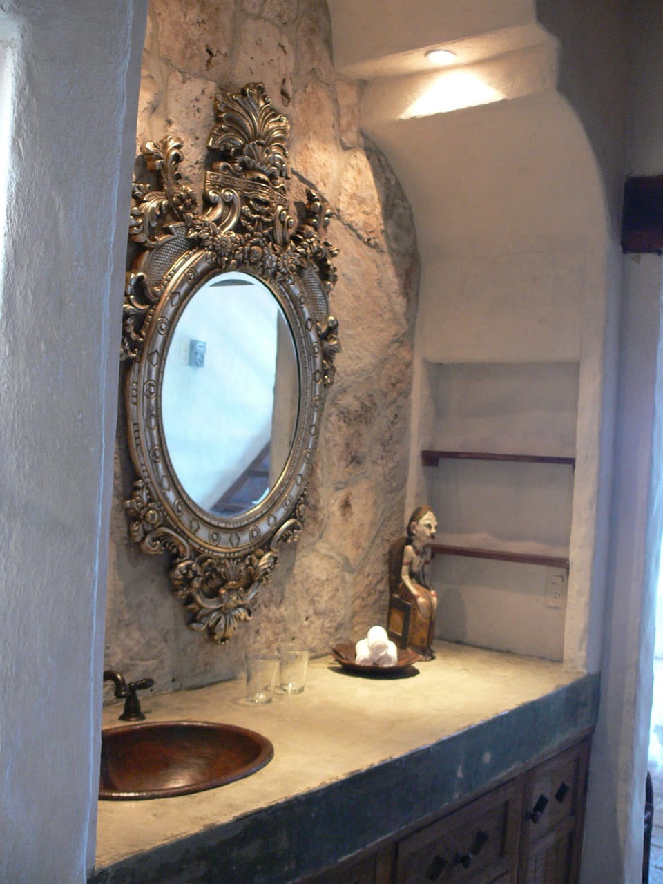 Separate vanity area with copper sinks beneath Moroccan arches.