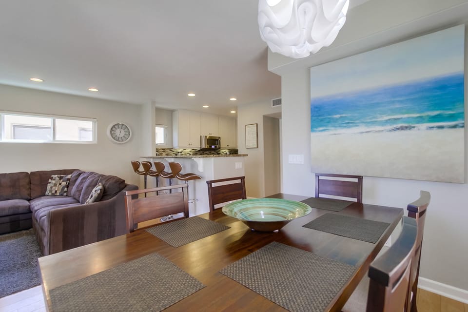 Dining area with kitchen and living room in background.