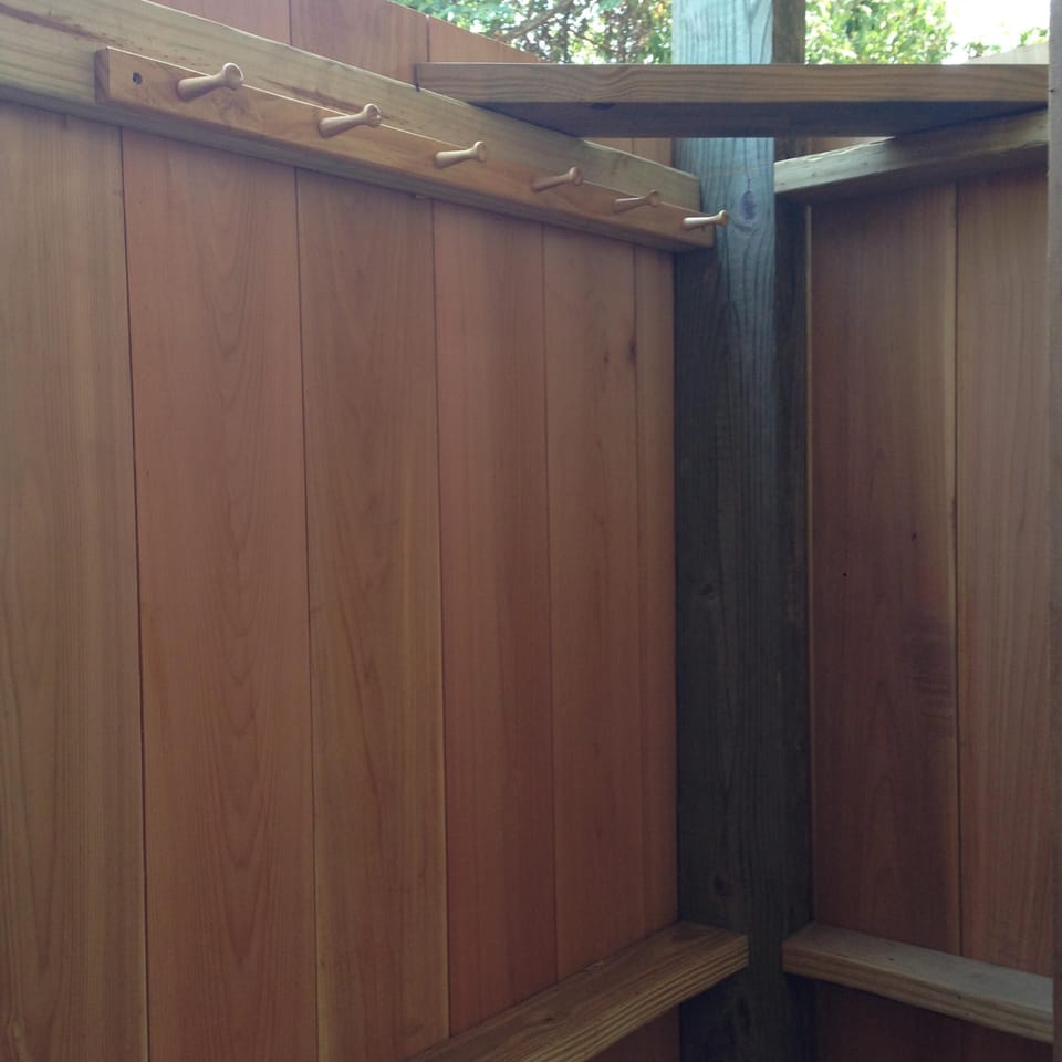 Pegs to hang personal items in outdoor shower