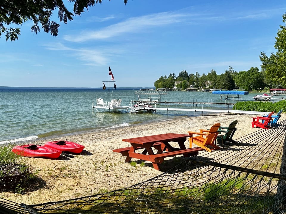 Shady hammock overlooking a beautiful sandy beach on a sparkling Burt Lake