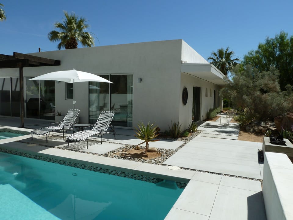 Backyard corner pool view with bedroom and patios