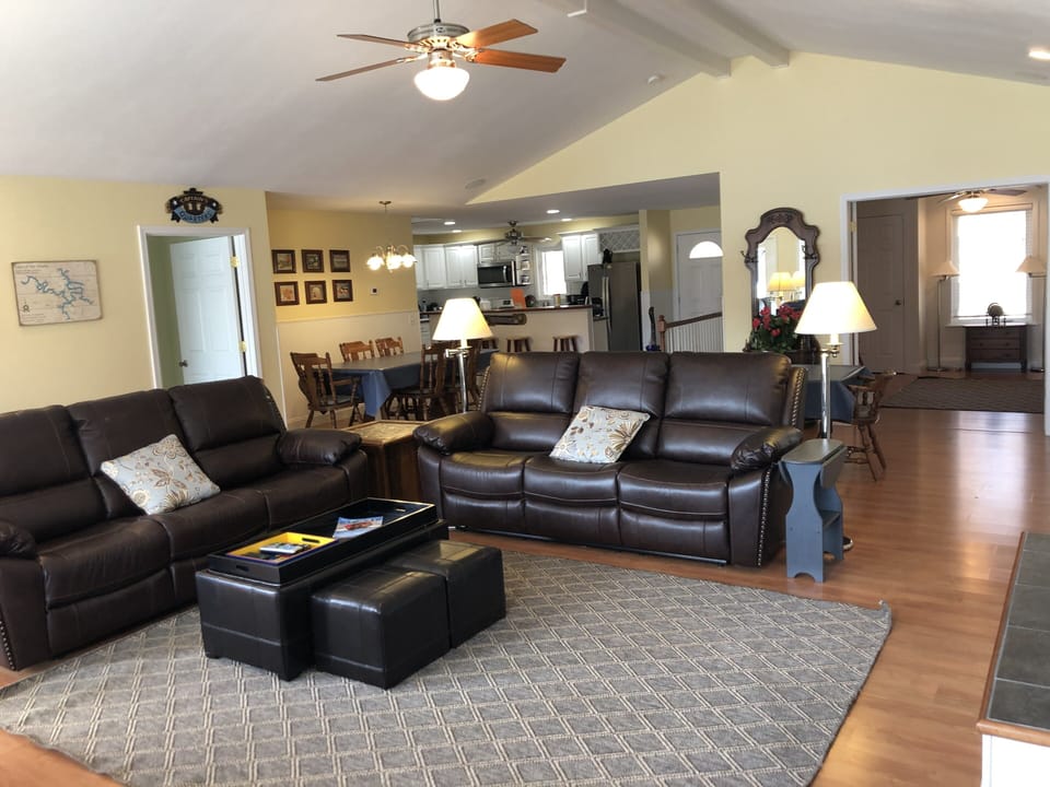 Large bright living room with tons of seating and leather sofas with Recliners