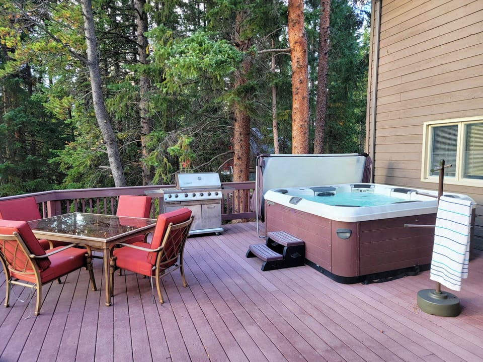 outdoor seating, gas grill and hot tub on large back deck