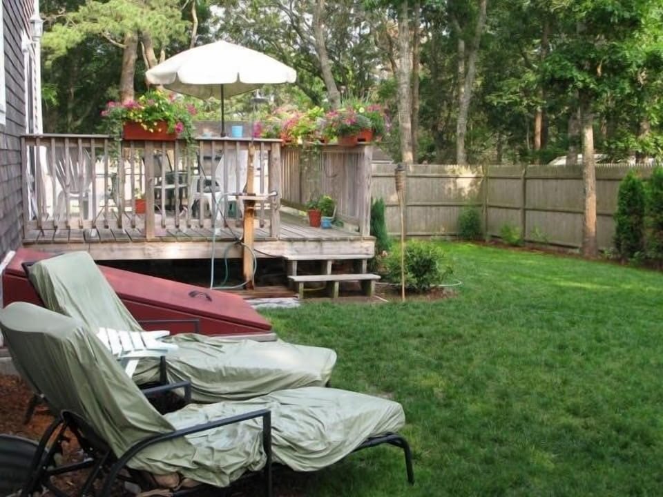 Fenced in back yard with deck, grill & outdoor dining.