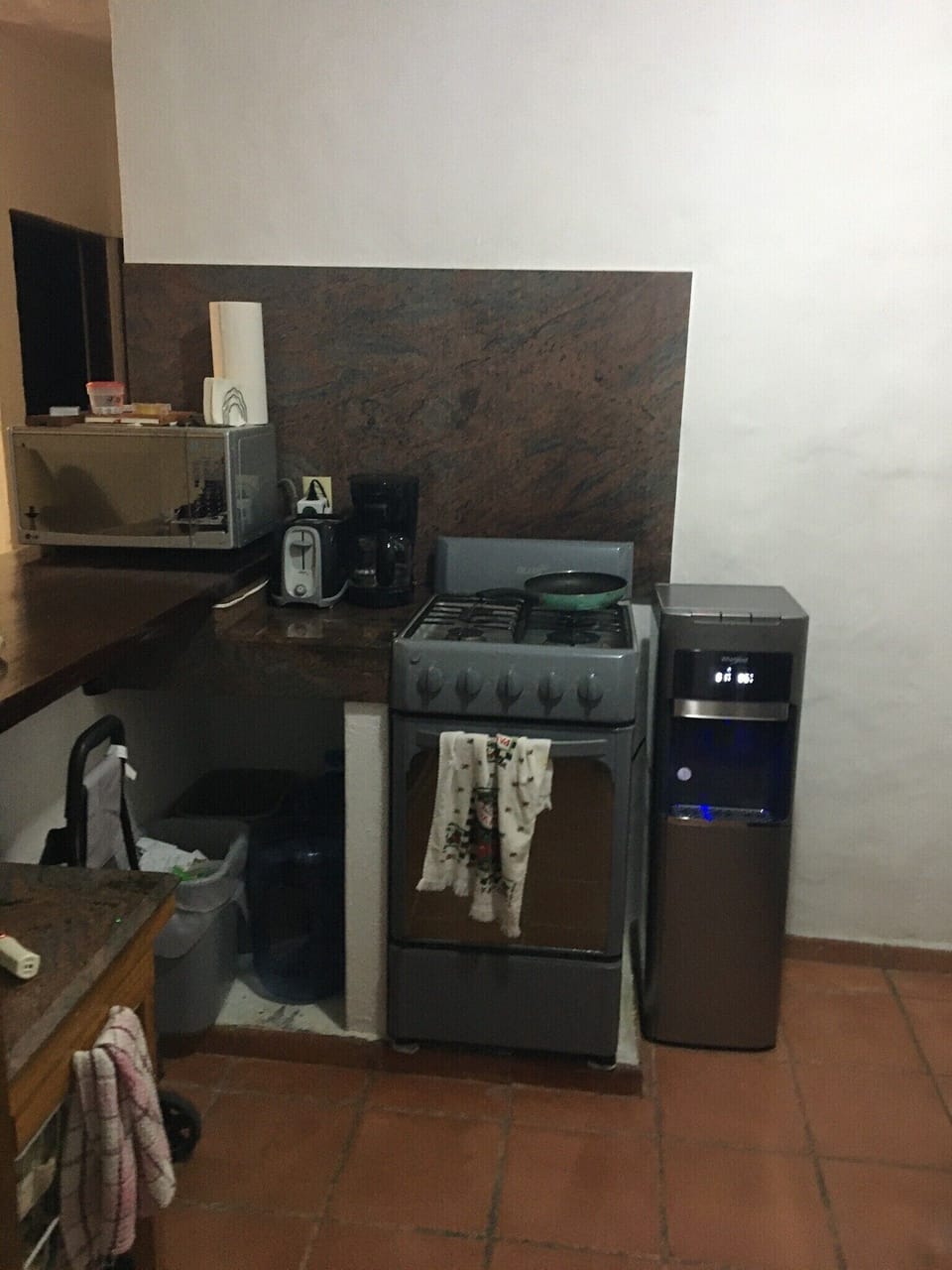 Kitchen with bottom load water cooler/ heater, gas stove, microwave, toaster.