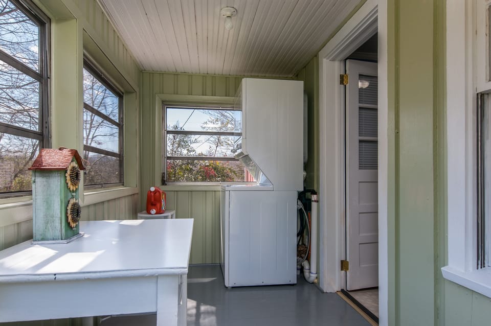 ENCLOSED PORCH - Adjacent to Kitchen, includes washer/dryer, desk/table, stools.
