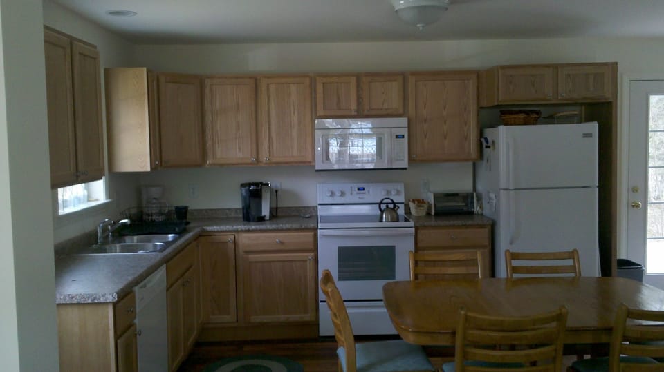 Kitchen with refrigerator, stove/oven, microwave, dishwasher, coffee makers.
