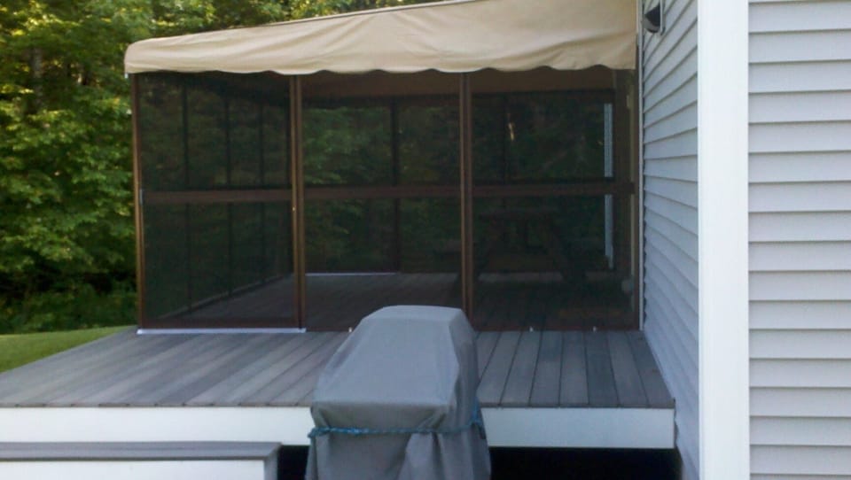 Screen porch with picnic table.  Gas grill in foreground.