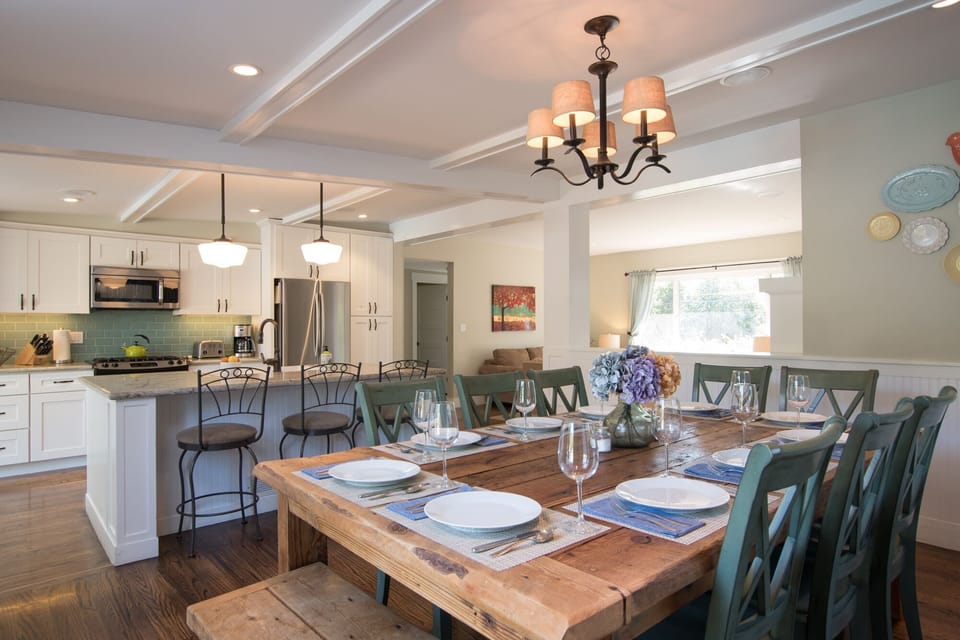 Open plan kitchen with large island and 3  bar seats adjacent to dining area