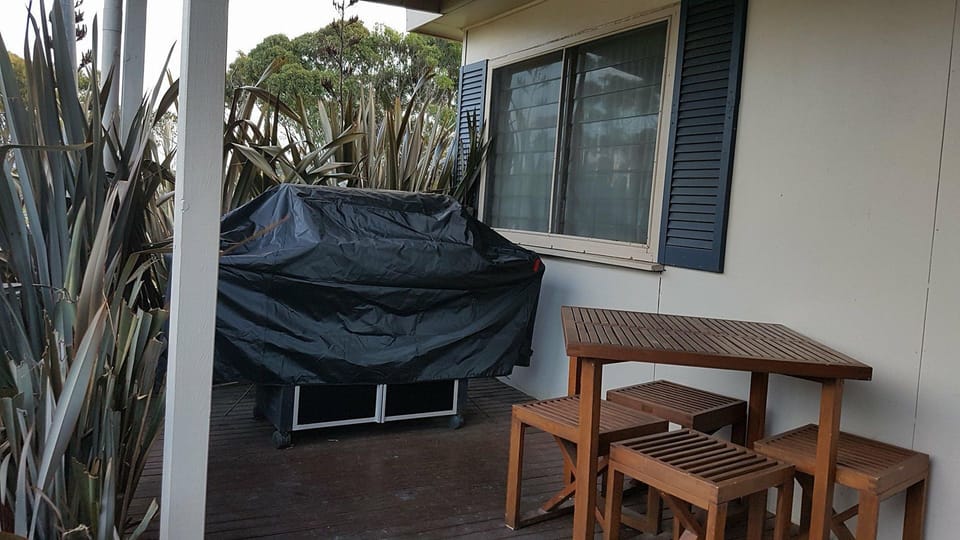 The outdoor veranda has a BBQ, table and stools.