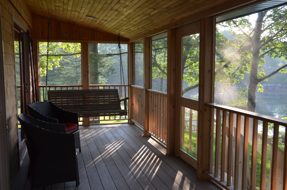 The screened porch with glider is a calm spot to watch the tide and relax