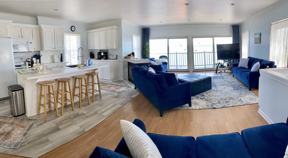 View from dining area - kitchen island with 4 stools, living area with 4 couches