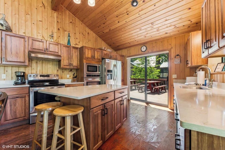 Sliding doors off of kitchen area that leads to the bbq and two picnic tables. 