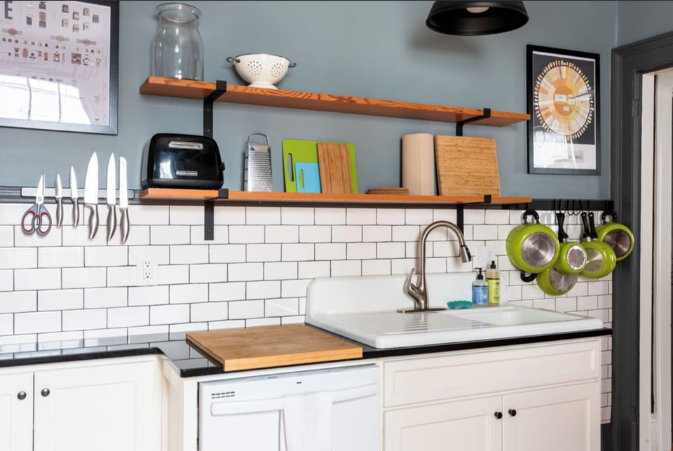 Second kitchen, w/vintage sink, open shelving, and cooking utensils