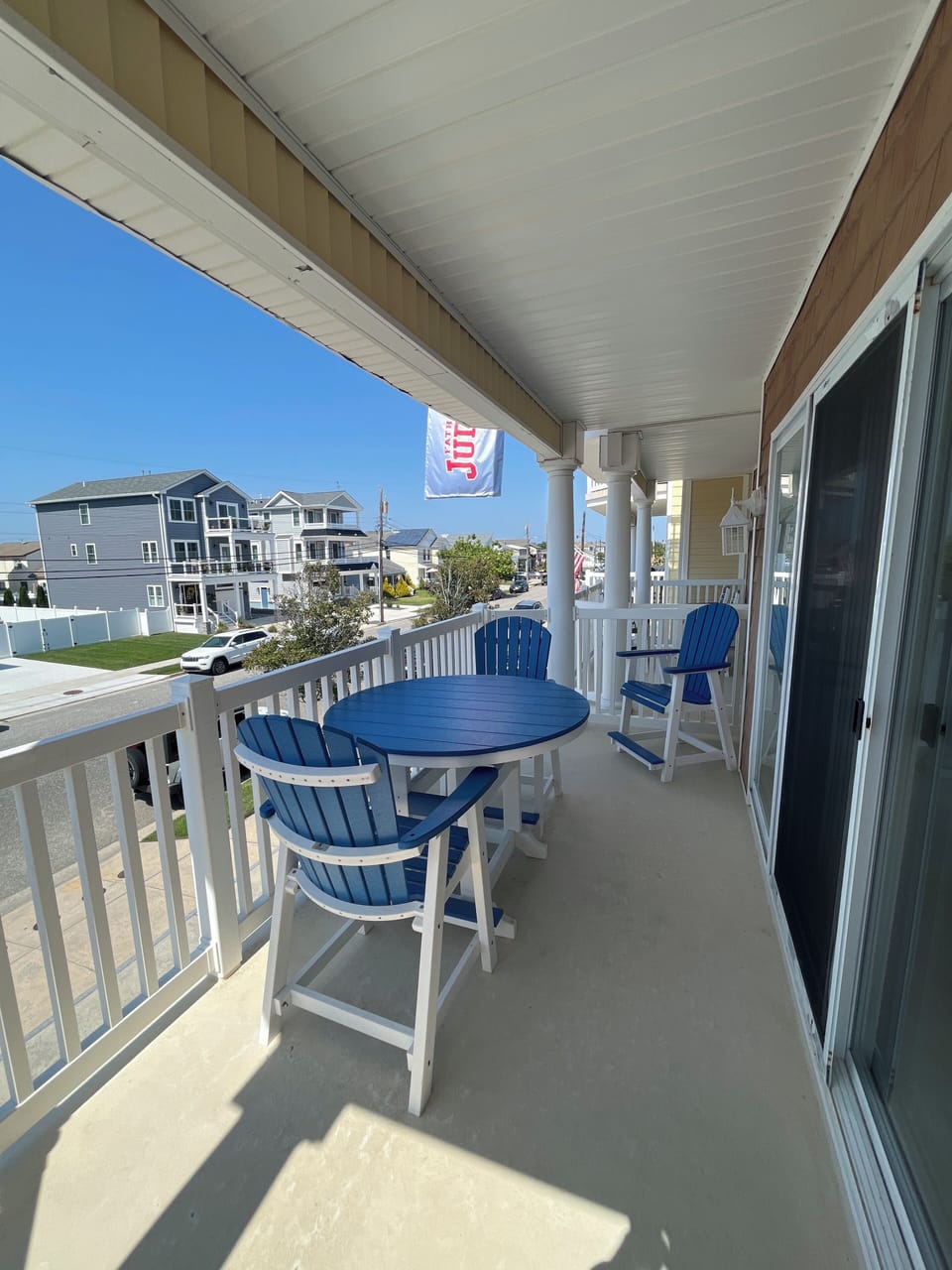 Covered porch with four chairs and table.