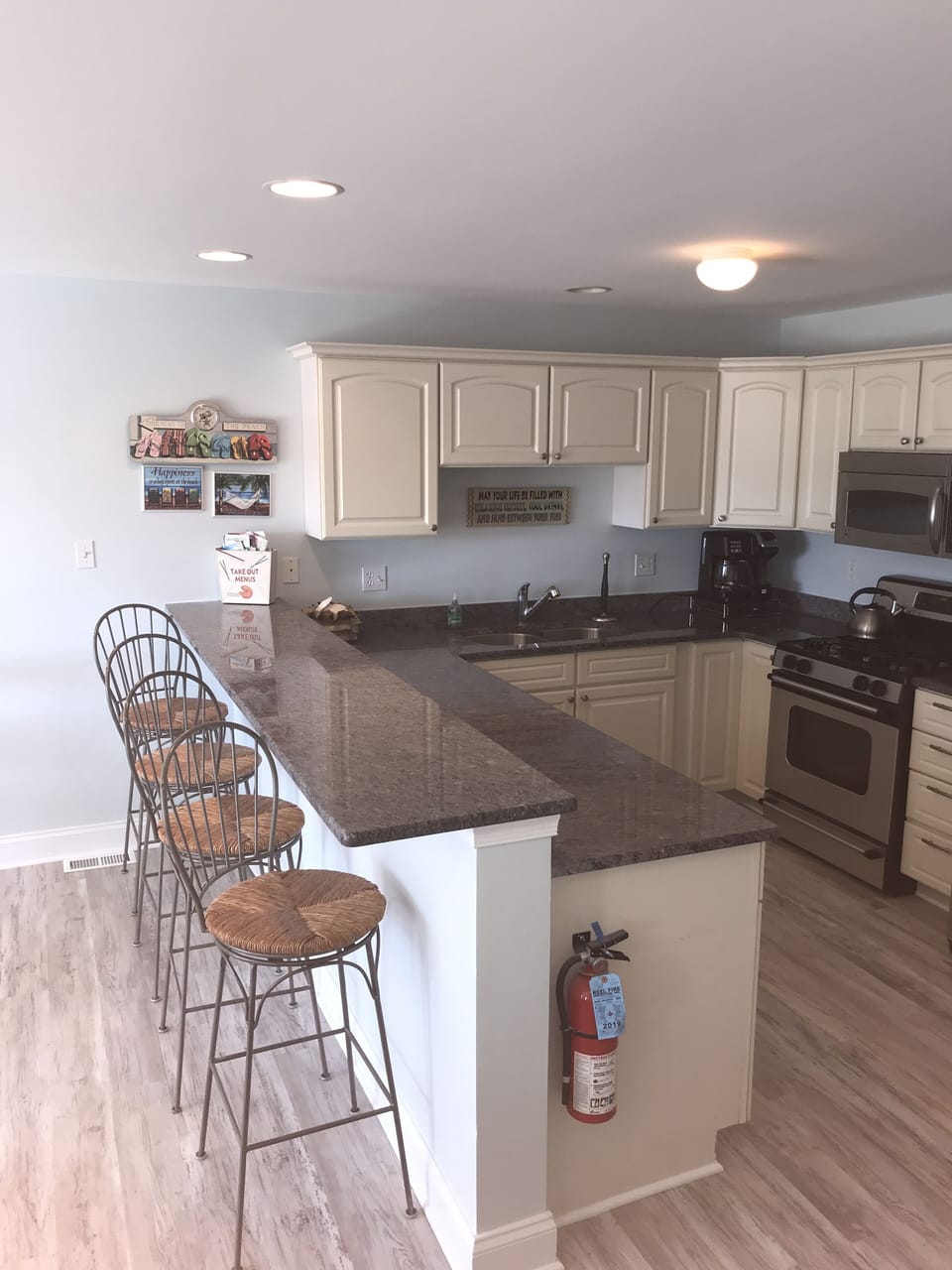 Kitchen area with breakfast bar seating for 4 stainless steel appliances 