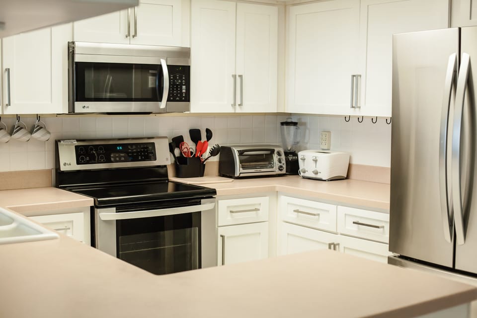 Kitchen with stainless appliances overlooking living and dining rooms
