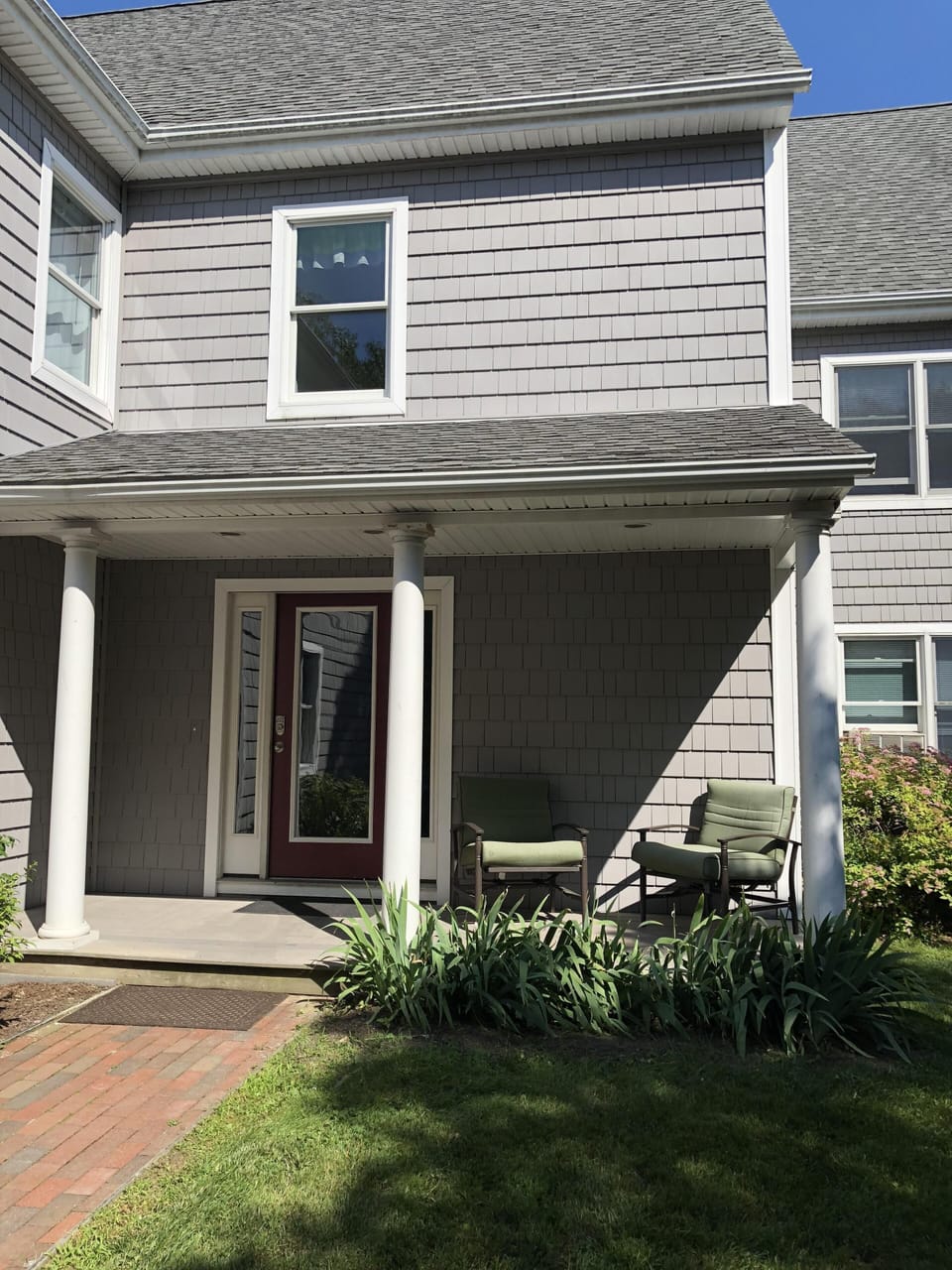 front door with porch and two chairs