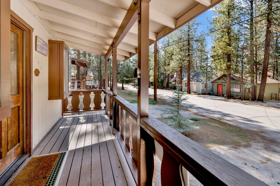 Welcoming cabin entry surrounded by towering pine trees, offering fresh mountain air and a peaceful forest setting—the perfect first impression for your Big Bear Lake getaway.