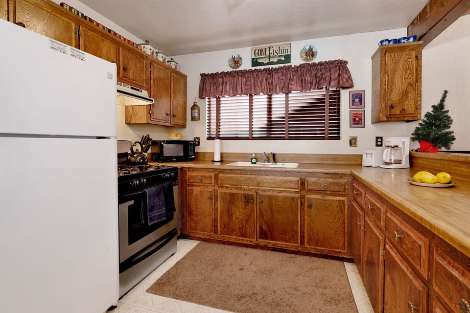 Fully equipped cabin kitchen with ample cabinetry, stove, fridge, microwave, and coffee maker—perfect for cooking meals, morning coffee, and feeling right at home on your stay.