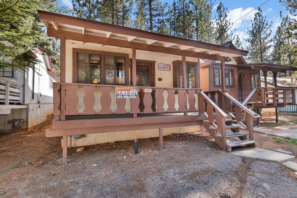 Welcoming cabin entry surrounded by towering pine trees, offering fresh mountain air and a peaceful forest setting—the perfect first impression for your Big Bear Lake getaway.