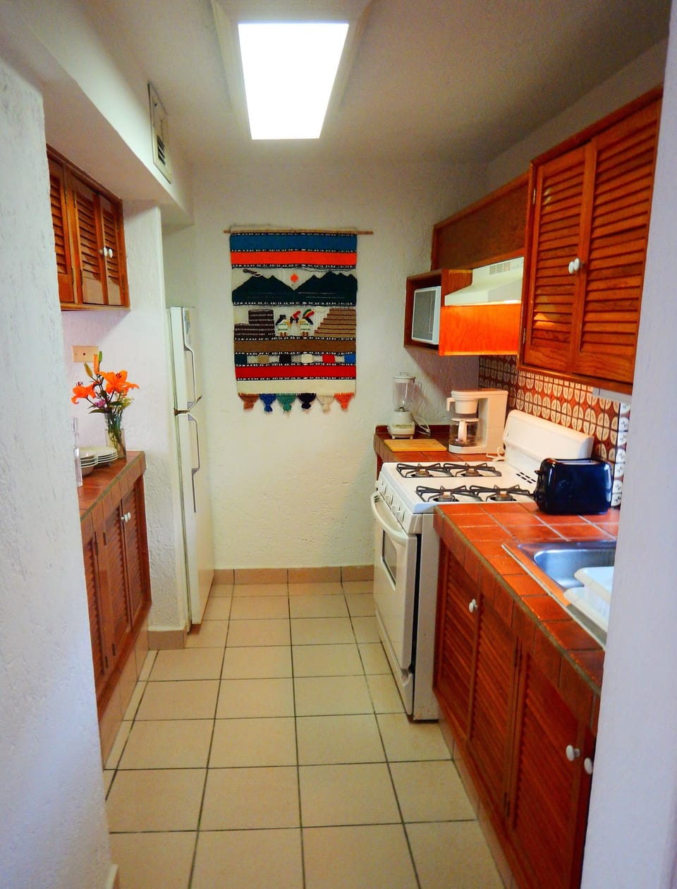 Kitchen of 2-bedroom condo with all appliances and utensils