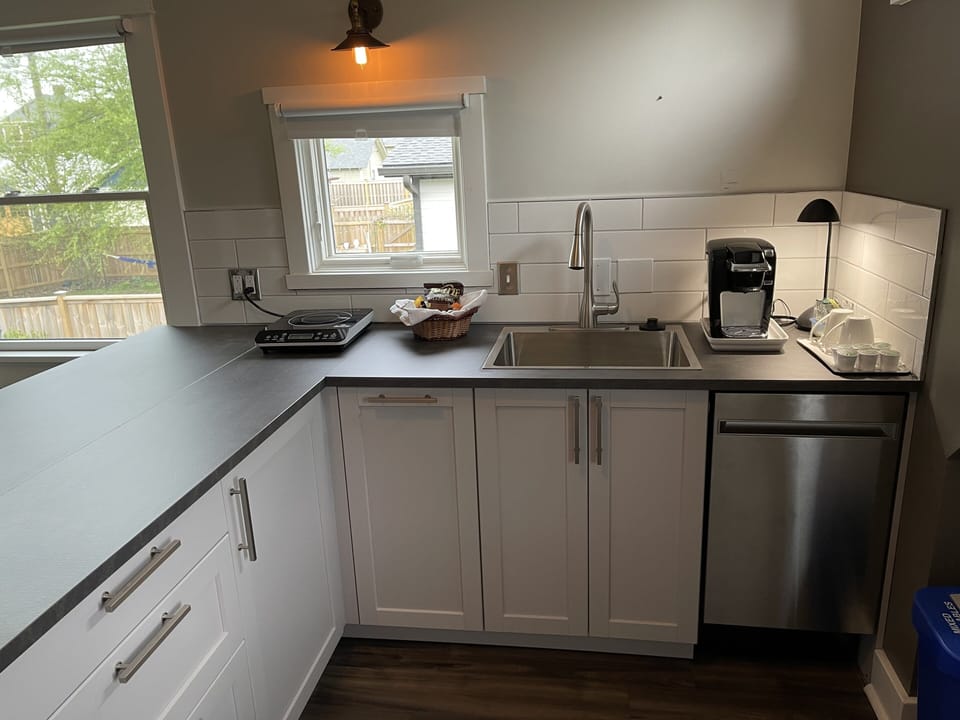 Kitchenette with dishes, cookware, a Keurig machine, dishwasher, hot plate, etc.