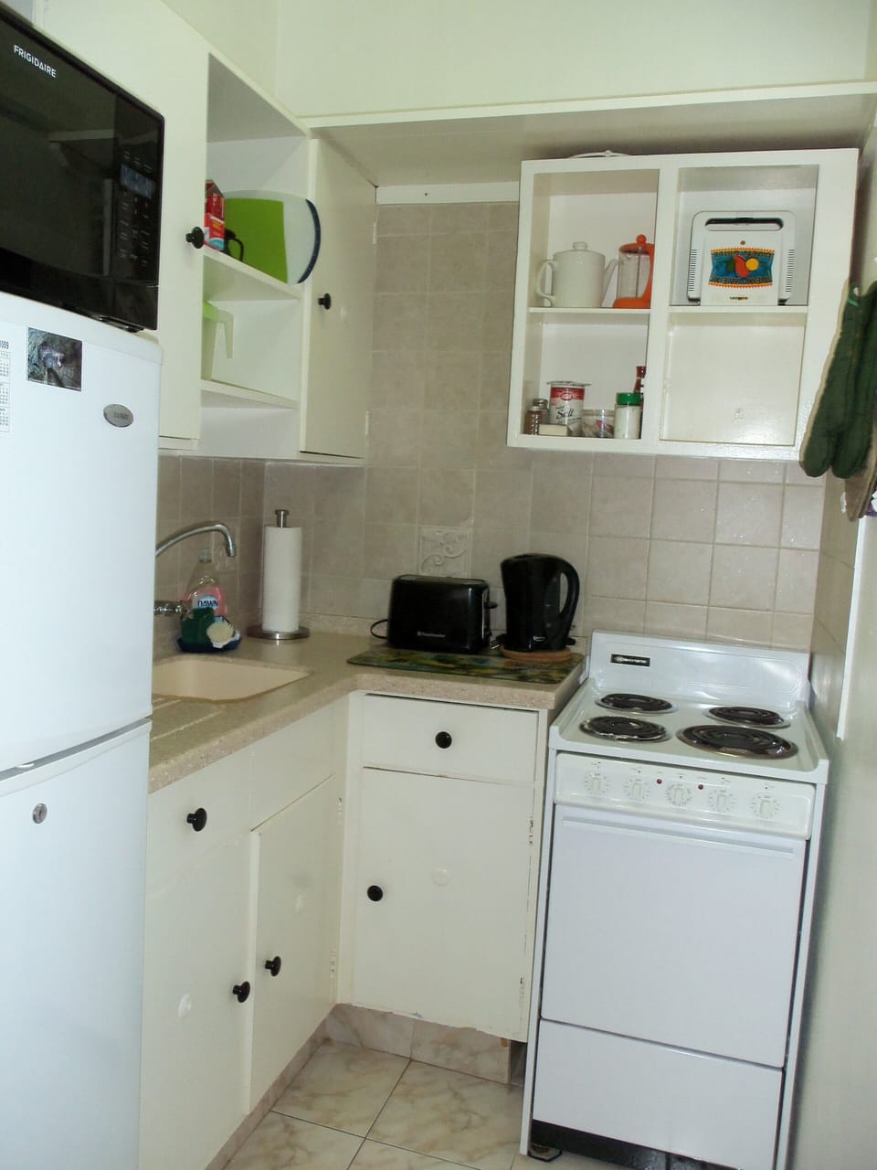 Kitchen with all plates/utensils, stove, fridge, microwave, toaster, kettle, etc