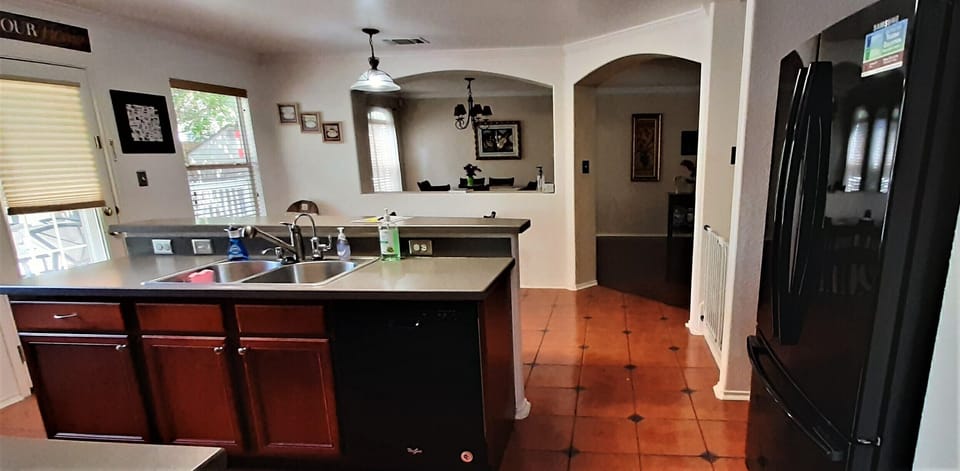 Kitchen sink, dishwasher and ref. Door on left going to backyard