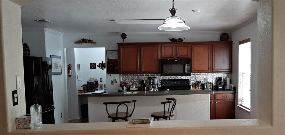 Kitchen as seen from the dining area with two bar stools