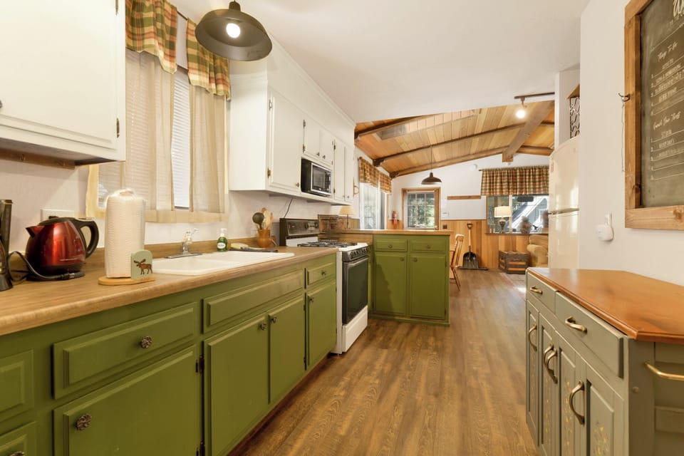 Fully equipped cabin kitchen with ample cabinetry, stove, fridge, microwave, and coffee maker—perfect for cooking meals, morning coffee, and feeling right at home on your stay.