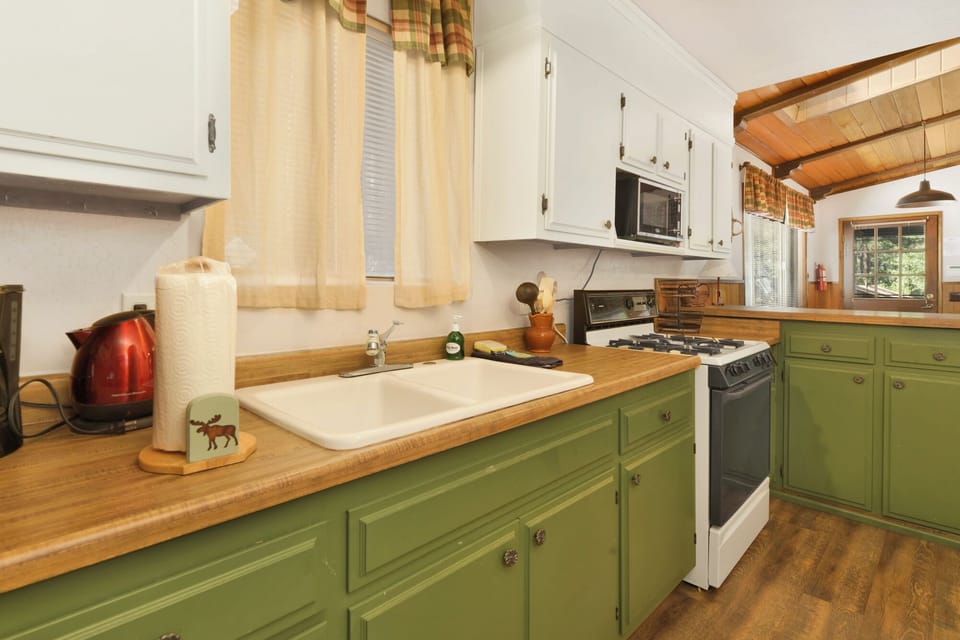 Fully equipped cabin kitchen with ample cabinetry, stove, fridge, microwave, and coffee maker—perfect for cooking meals, morning coffee, and feeling right at home on your stay.