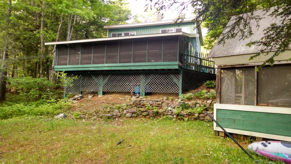 Screen house and camp from pond side. Lots of room for lawn chairs in the shade.