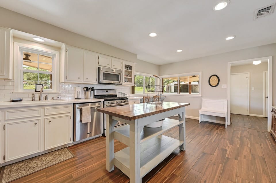 Fully equipped kitchen with stainless steel appliances and quartz countertops.