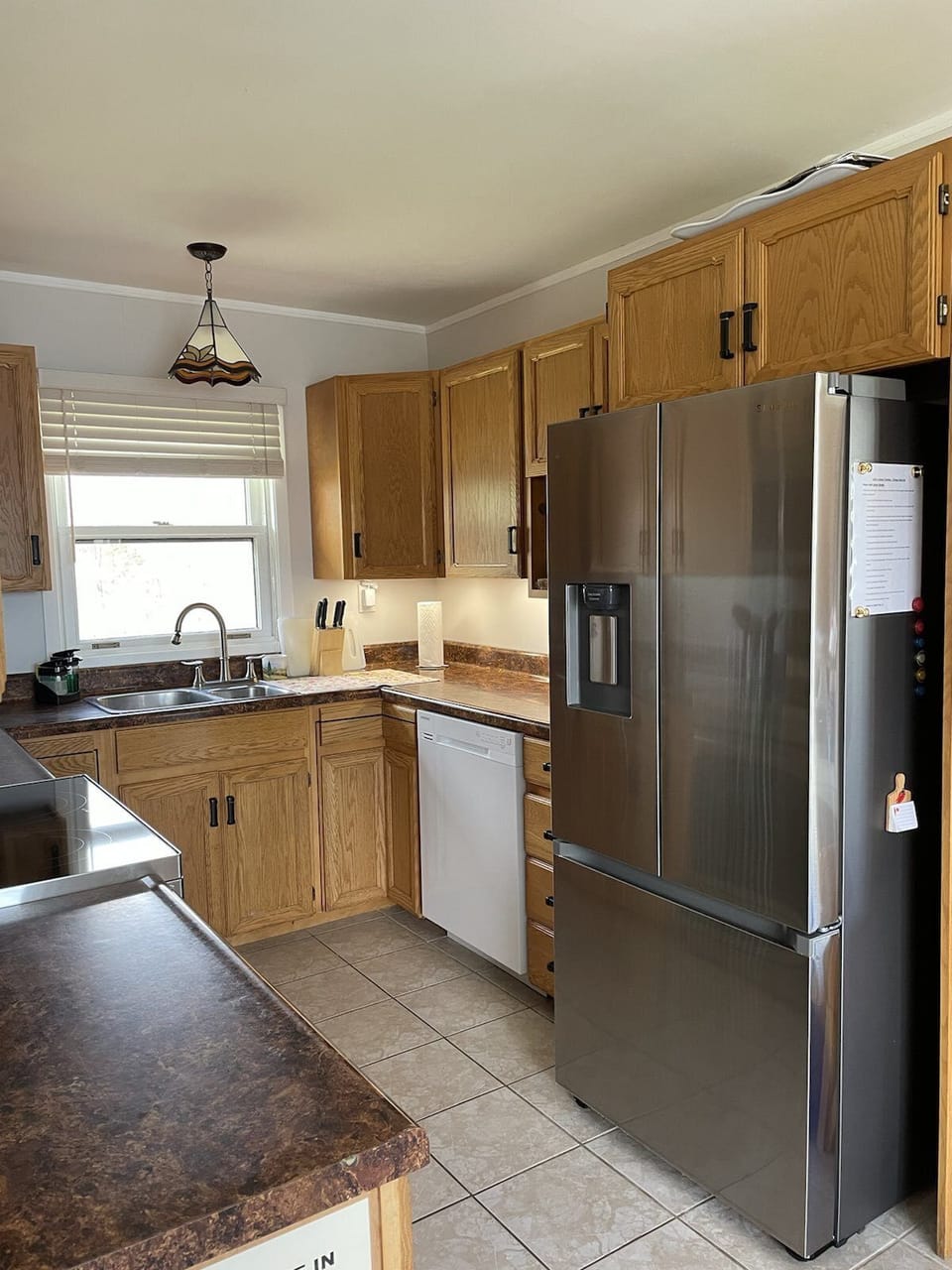 Dishwasher and double door refrigerator with freezer drawer.