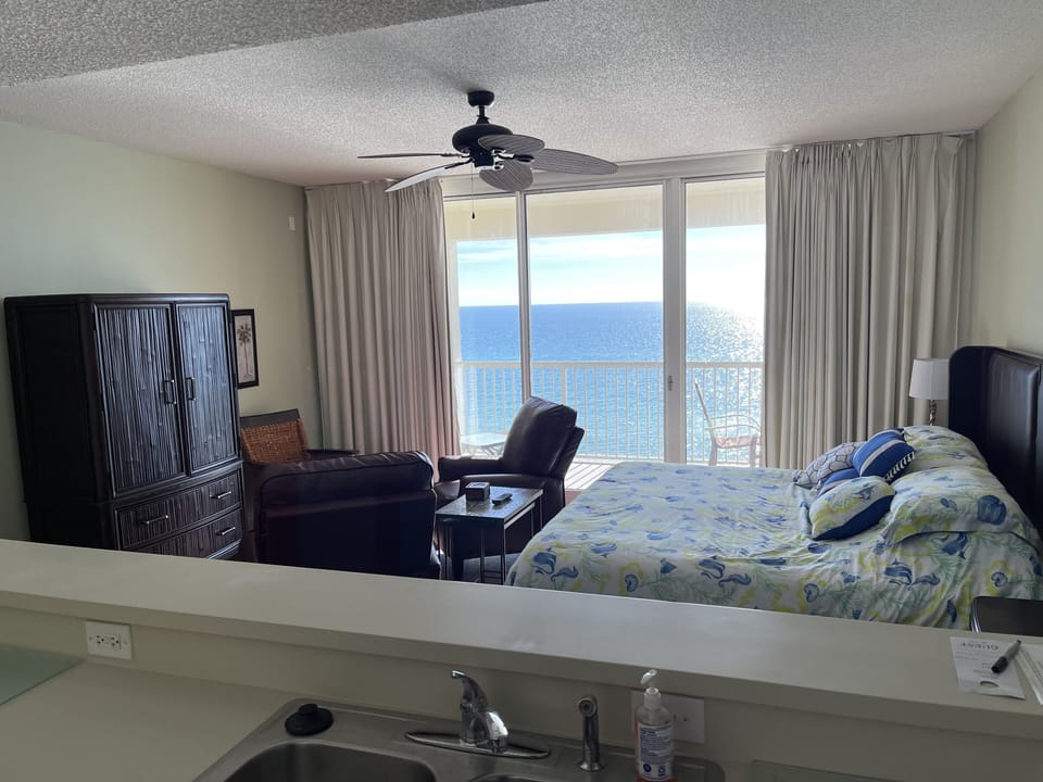 View of the living area and beachfront balcony from the kitchen. Beach in view!