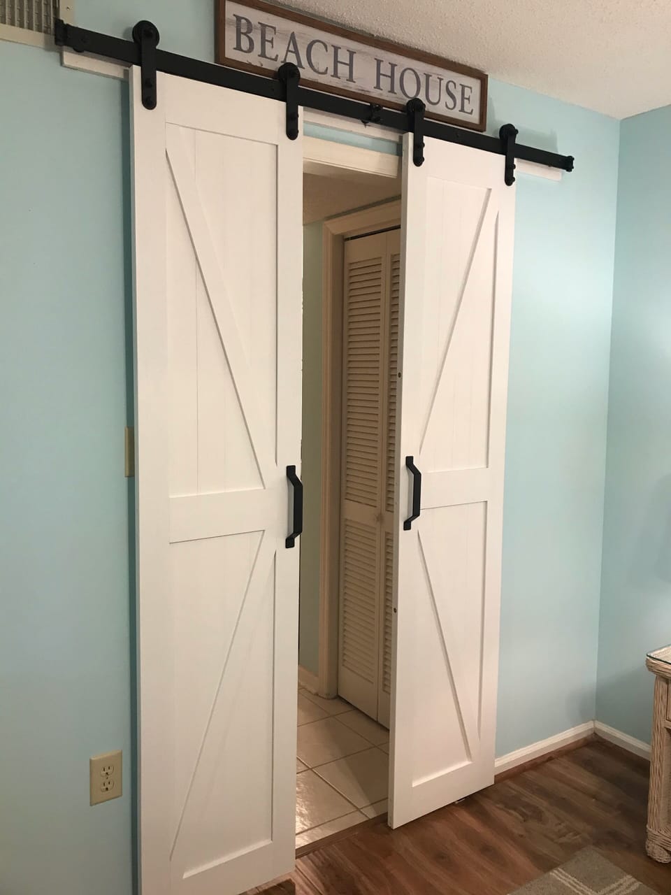 Barn doors separating master bathroom area. 