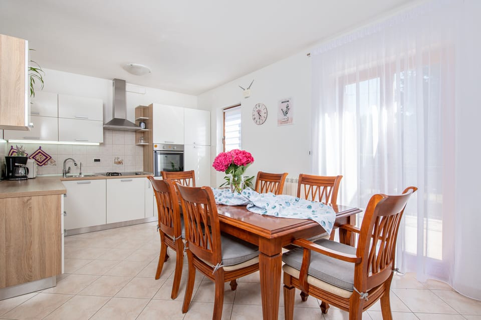 Capacious kitchen along with the dining area with a big wooden table