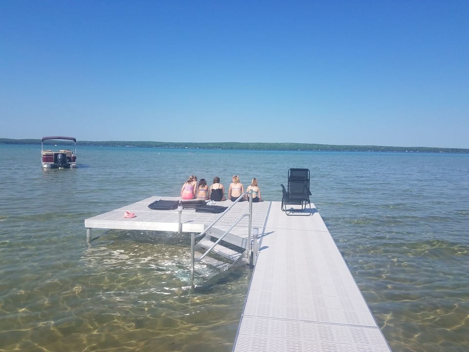 Making Memories.  4 reclining chairs on the dock. 3 buoys for water vehicles