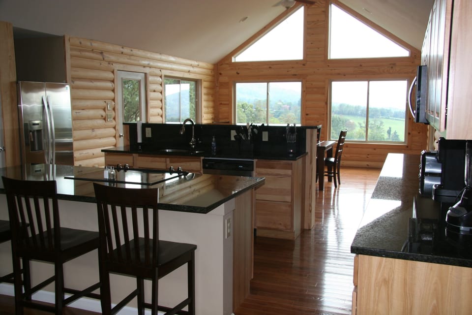 large kitchen with stainless steel appliances and black granite counter tops.