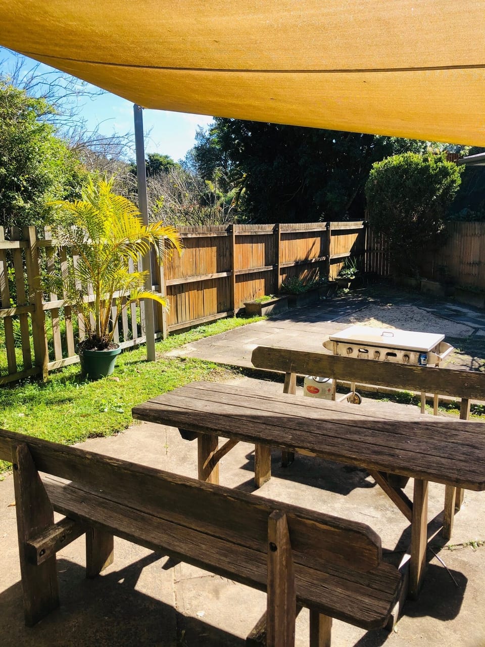 Outdoor enclosed area with BBQ, sandpit and setting. Fence overlooks park 
