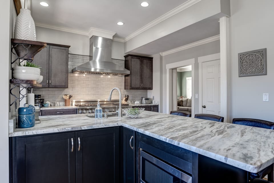 Kitchen island hosts seating for four and a large prep surface for family meals.