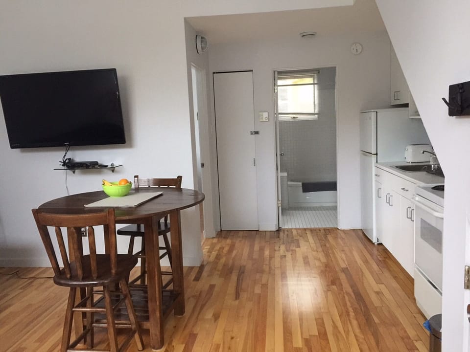 Open plan living room, kitchen, showing bedroom to left and bathroom in distance