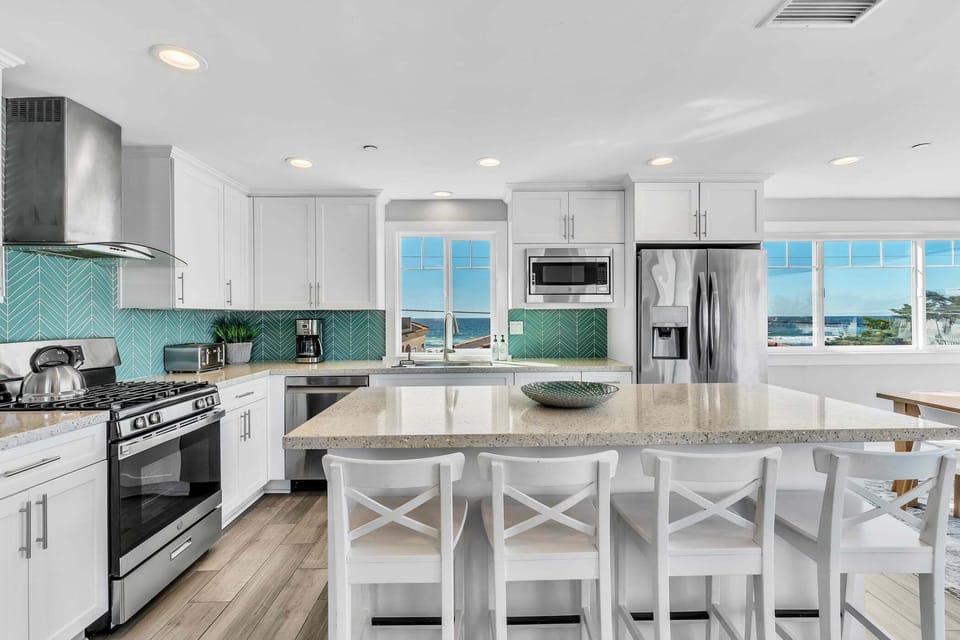 Modern kitchen with high-end appliances, spacious island, and coastal design.