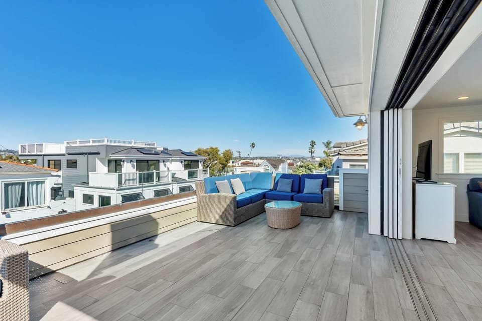 Wide sliding doors open fully to create a seamless indoor-outdoor experience, blending the living space with the balcony.